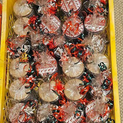 Korb mit vielen verpackten Geschenken, jeweils mit buntem Band und Glitzersterne verziert.