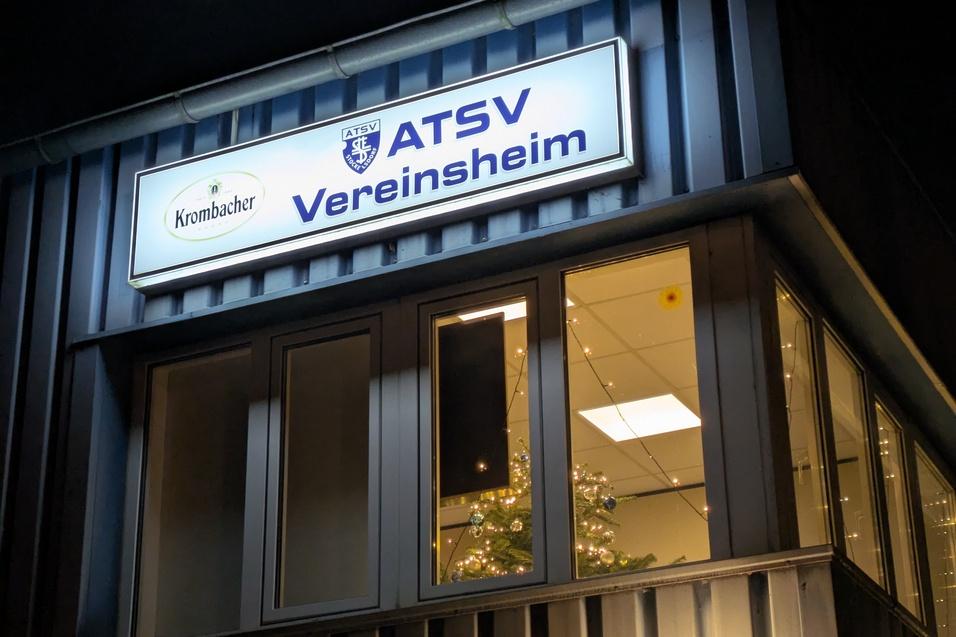 Beleuchtetes Vereinsheim des ATSV mit Krombacher-Schild und weihnachtlich dekoriertem Fenster.