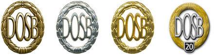 Vier Medaillen des DOSB in Gold, Silber und Bronze sowie eine spezielle 20-Jahr-Medaille mit dem Schriftzug "DOSB 20".